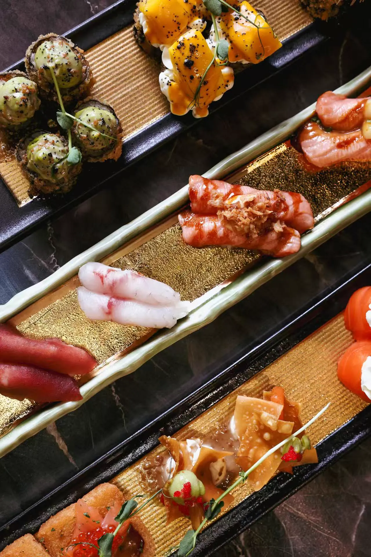 Sushis et makis sur plateaux dorés